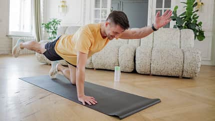 Bird Dog Mann macht den Bird Dog: Im Vierfüßlerstand einen Arm und diagonal das Bein ausstrecken.