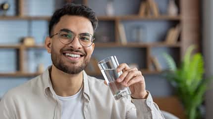 mature,friendly,happy,screen,smile,casual,uplifting,diverse,joyf Confident,Man,With,Glasses,Smiling,While,Holding,Glass,Of,Water