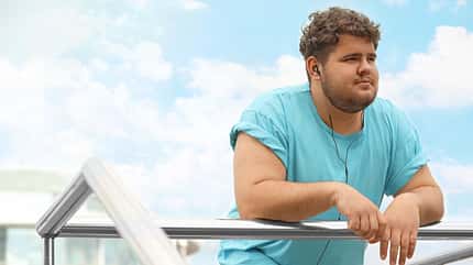 big,plump,caucasian,body,obese,space,fit,loss,music,problem,exer Young,Overweight,Man,Leaning,On,Railing,Outdoors