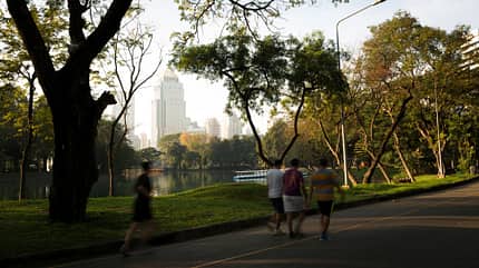 Menschen gehen durch Park in Thailand Menschen gehen durch Park in Thailand