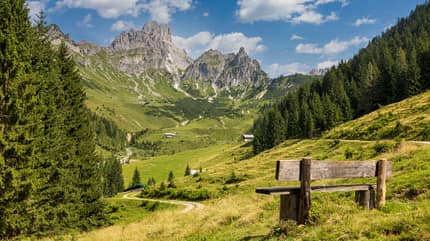 Bergkulisse in Österreich mit Bank im Vordergrund Bergkulisse in Österreich mit Bank im Vordergrund
