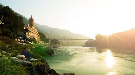 Blick auf Ganga Flußdamm, Lakshman Jhula Brücke und Tera Manzil Tempel, Trimbakeshwar in Rishikesh während des Sonnenuntergangs. Indien Blick auf Ganga Flußdamm, Lakshman Jhula Brücke und Tera Manzil Tempel, Trimbakeshwar in Rishikesh während des Sonnenuntergangs. Indien