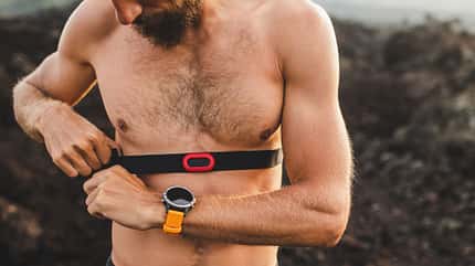 Männliche Läufer tragen professionelle Brust Herzfrequenz-Monitor und Vorbereitung für Trail-Lauf im Freien. Oben ohne Körper Nahaufnahme und Smart Watch oder Fitness-Tracker auf der Hand. Männliche Läufer tragen professionelle Brust Herzfrequenz-Monitor und Vorbereitung für Trail-Lauf im Freien. Oben ohne Körper Nahaufnahme und Smart Watch oder Fitness-Tracker auf der Hand.