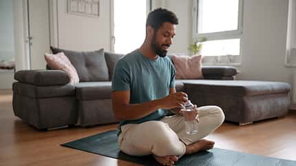 Man drinking water after exercising, hydrating himself. Morning workout or meditation routine for a young single man. Man drinking water after exercising, hydrating himself. Morning workout or meditation routine for a young single man.