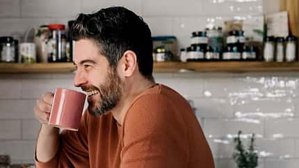 Mann trinkt Kaffee und lacht Mann trinkt Kaffee und lacht