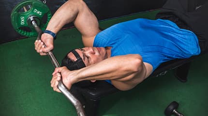 muscular,southeast asian,weight training,upper arms,ez curl bar, An,Athletic,Male,Does,A,Set,Of,Lying,Tricep,Extensions,