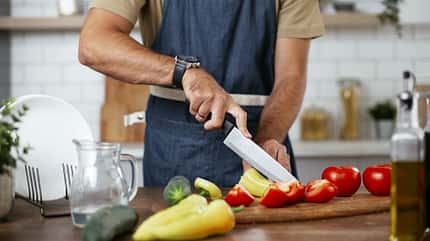 Mann, der Gemüse schneidet und kocht Mann, der Gemüse schneidet und kocht