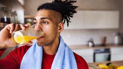 Mann trinkt Orangensaft aus einem Glas Mann trinkt Orangensaft aus einem Glas