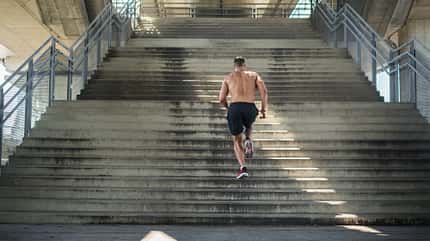 Mann von hinten der eine Treppe hochjoggt Mann von hinten der eine Treppe hochjoggt