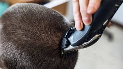 Männlicher Kopf mit Buzz Cut und Rasierer Männlicher Kopf mit Buzz Cut und Rasierer