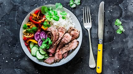 Gesunde Buddha Bowl: gegrilltes Rindersteak, gebratenes und frisches Gemüse, Reis auf dunklem Hintergrund Gesunde Buddha Bowl: gegrilltes Rindersteak, gebratenes und frisches Gemüse, Reis auf dunklem Hintergrund
