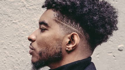 Portrait von einem stylischen jungen Mann mit Undercut und Bart