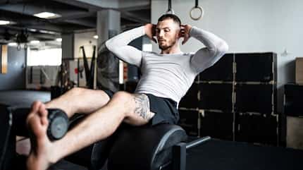 Ein Mann trainiert seinen Bauch an einer Maschine im Gym Ein Mann trainiert seinen Bauch an einer Maschine im Gym