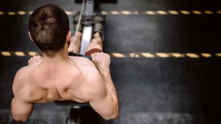 Mann trainiert an der Rudermaschine  Mann trainiert an der Rudermaschine