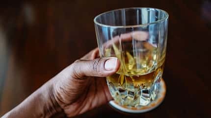 Eine Hand, die ein Glas mit Apfelessig hält Eine Hand, die ein Glas mit Apfelessig hält
