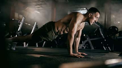 Ein Mann, der sich in der hohen Planke befindet