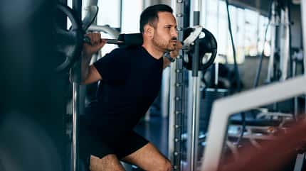 Ein Mann macht Kniebeugen 