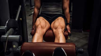 Muscular man doing legs in the gym