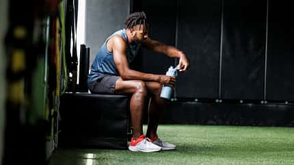 Ein Mann trinkt Wasser im Gym