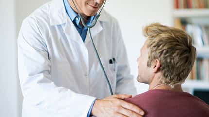 25-29 years,35-39 years,adult,adults only,care,color image,cropped,day,doctor,examining,expertise,hand on shoulder,health,horizontal,indoors,lab coat,listening,mallorca,man,medical,medical exam,medical examination,mid-adult,mid-adult man,occupation,only men,patient,physician,selective focus,stethoscope,two people,young adult,young man Doctor using stethoscope on patient