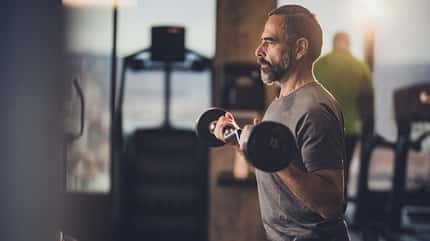 Ein Mann beim Krafttraining mit einer Langhantel Ein Mann beim Krafttraining mit einer Langhantel