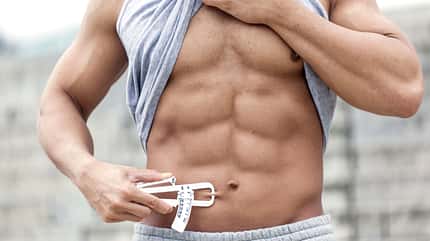 Athletic man checkin body fat.