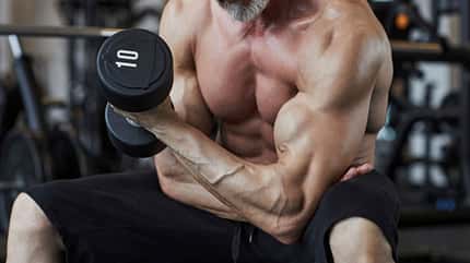 Ein Mann trainiert oberkörperfrei seinen Bizeps