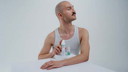 Mann im Unterhemd mit Produkten von NØ COSMETICS