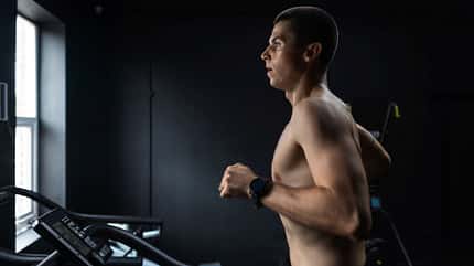 Ein Mann läuft oberkörperfrei auf dem Laufband 