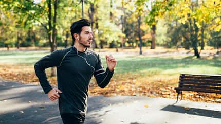 Ein Mann joggt durch die Herbstlandschaft Ein Mann joggt durch die Herbstlandschaft