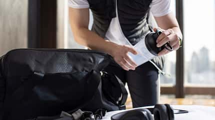 Ein Mann packt seine Sporttasche mit seinem Equipment. Ein Mann packt seine Sporttasche mit seinem Equipment.