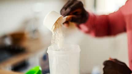 Proteinpulver wird in einen Shakebehälter gefüllt Proteinpulver wird in einen Shakebehälter gefüllt