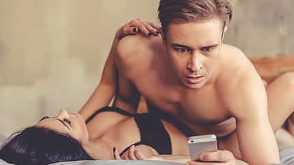 sh_VGstockstudio_514793329_mann_bett_frau_paar_handy_800x533