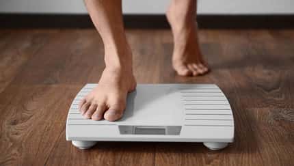 Man,Standing,On,Weight,Scale