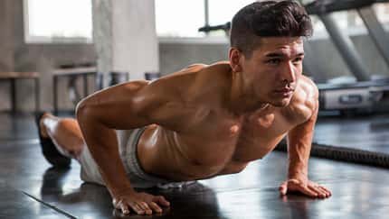 Starkes Fitnessmodel bei Push-ups im Gym