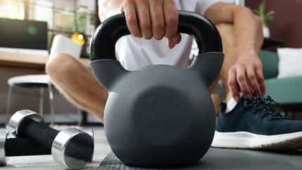 Mann nimmt eine Kettlebell in die Hand