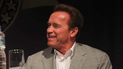 Arnold Schwarzenegger lachend auf einer Pressekonferenz in Rio.