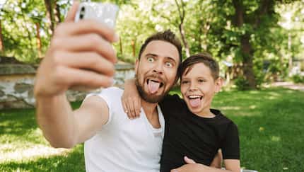 Vater und Sohn machen Faxen für ein Selfie