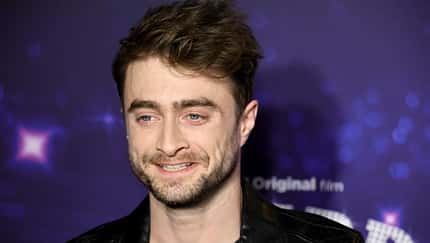 Daniel Radcliffe lächelt auf Premiere in die Kamera