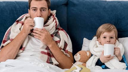 Ein Vater und sein Sohn liegen krank im Bett
