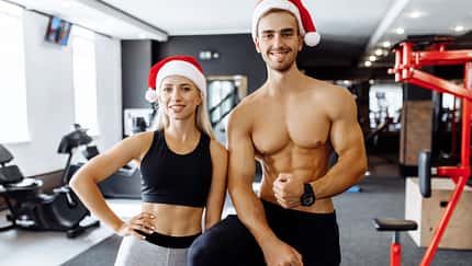 Happy,Sporty,Couple,,In,Santa,Claus,Hats,In,Sportswear,,Show