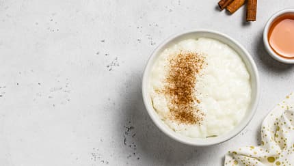 Eine Schale mit Reispudding steht auf einem hellen Untergrund