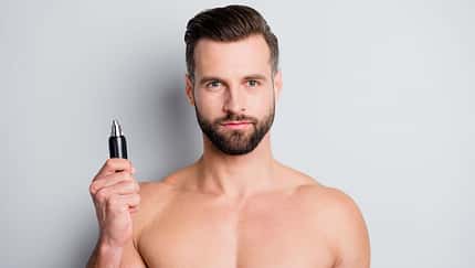 Mann hält einen Trimmer in der Hand