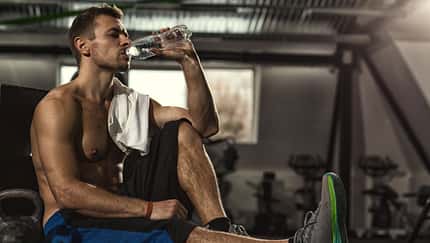 Man ruht sich beim Training aus und trinkt