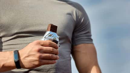 Mann isst einen Proteinriegel