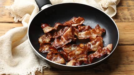 Delicious,Bacon,Slices,In,Frying,Pan,On,Wooden,Table