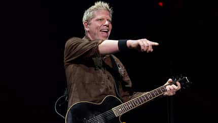 Dexter Holland singt auf der Bühne und hält eine Gitarre