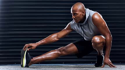 Male,Athlete,,Exercise,And,Stretching,Leg,With,Hand,For,Sports,