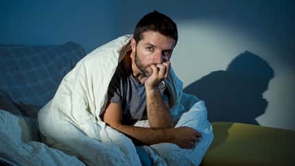Young,Sick,Man,Sitting,On,Couch,At,Home,Scary,And