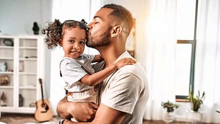 Ein Vater küsst seine kleine Tochter